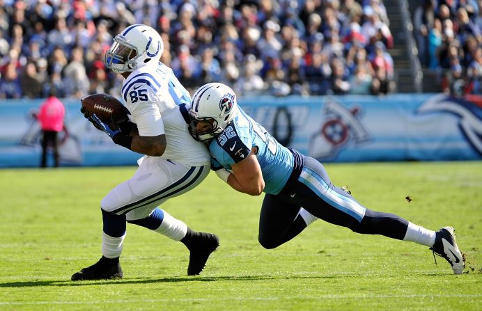 Colin McCarthy of the Tennessee Titans tackles Weslye Saunders of the Indianapolis Colts on Sunday in Nashville.