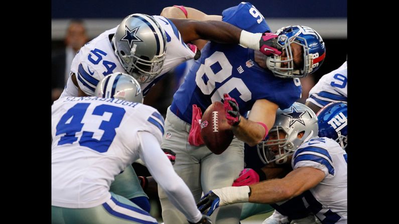 Bear Pascoe of the New York Giants fumbles the ball under pressure from No. 54 Bruce Carter, No. 52 Dan Connor and No. 43 Gerald Sensabaugh of the Dallas Cowboys at Cowboys Stadium on Sunday, October 28, in Arlington, Texas.