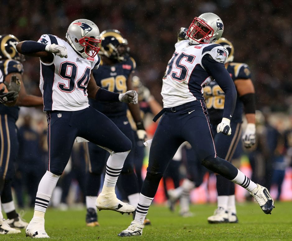 Justin Francis (94) and Patriots teammate Chandler Jones (95) celebrate after sacking the Rams' quarterback.