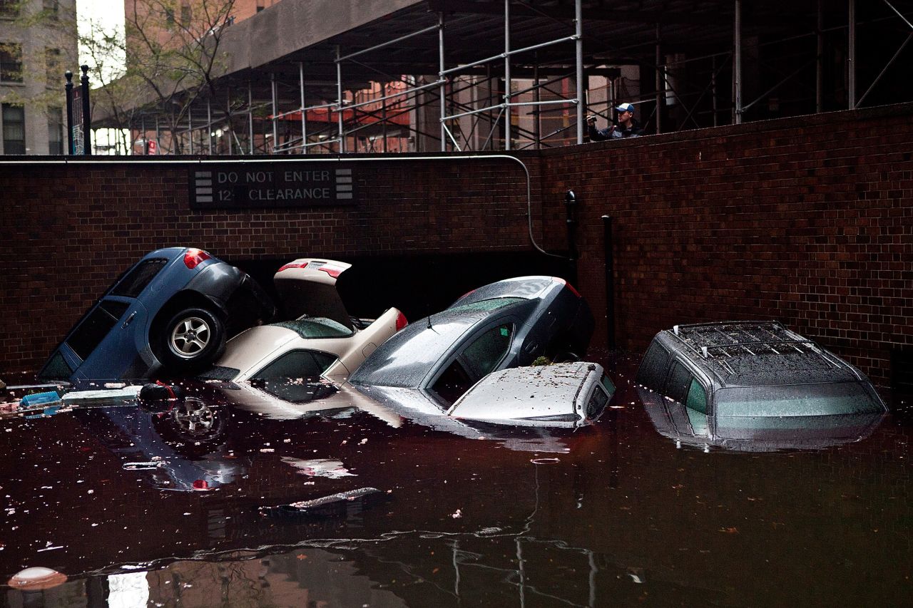Cars float in a flooded below-street-level parking area in the Financial District on Tuesday.