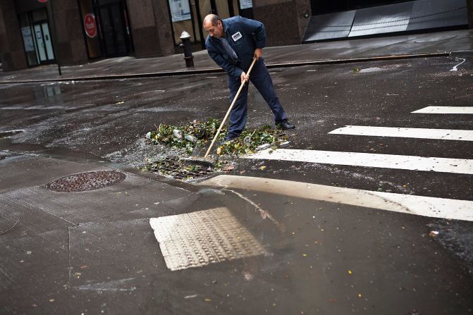 Ramiro Arcos clears debris from a storm drain in the Financial District of New York after Sandy swept through the city. 