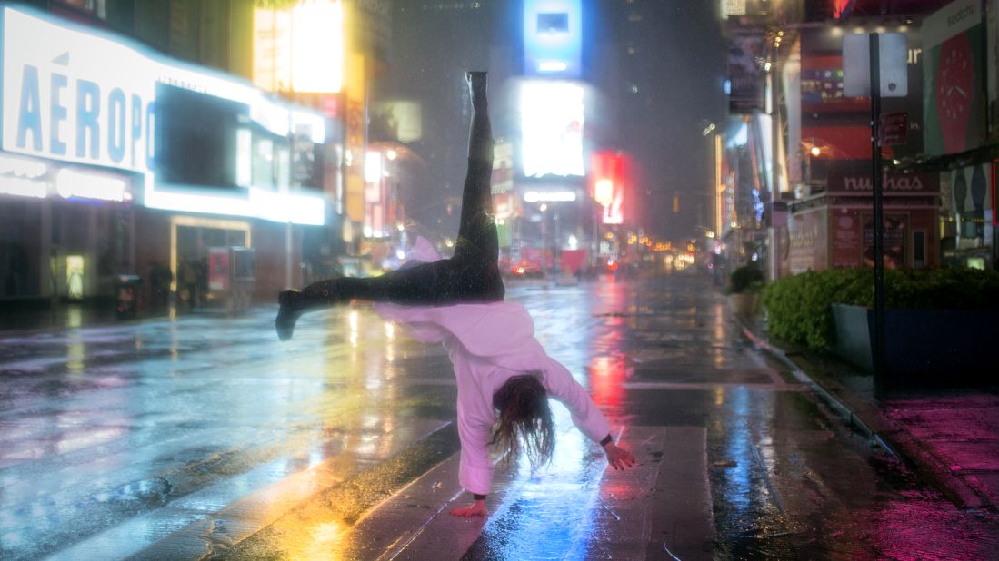 A visitor does a cartwheel in the rain in New York's Times Square on Monday, October 29.