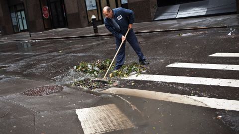 Ramiro Arcos sweeps debris from damage caused by Hurricane Sandy on Tuesday in New York's financial district.