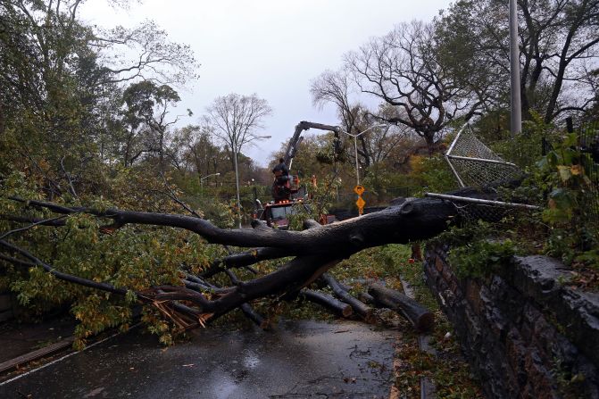 Workers clear a tree blocking East 96th Street in Central Park in New York on Tuesday. 