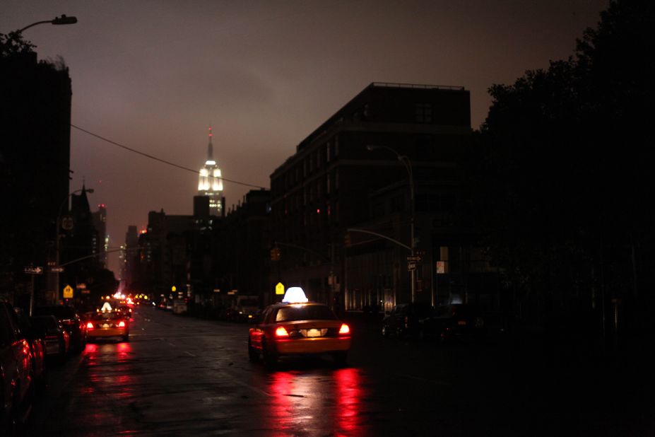 Taxis drive down a New York street where the power was out late Monday, October 29.