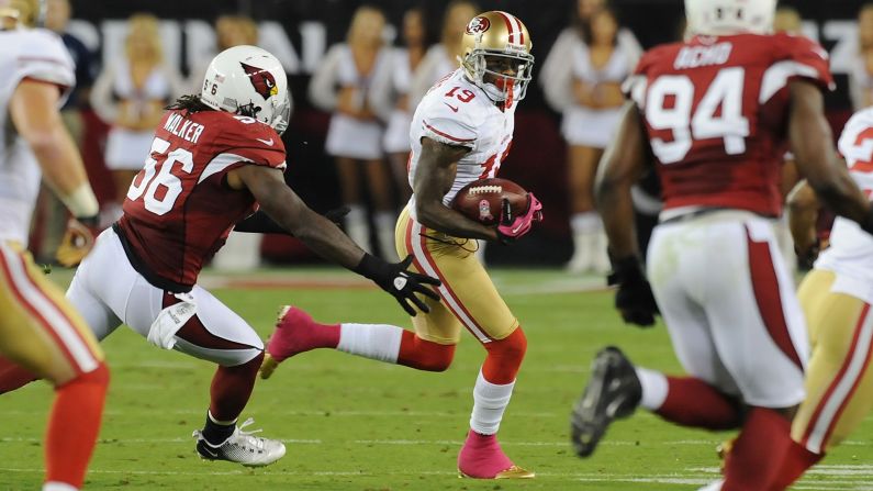 Ted Ginn Jr. of the San Francisco 49ers runs the ball past Reggie Walker of the Arizona Cardinals on Monday.