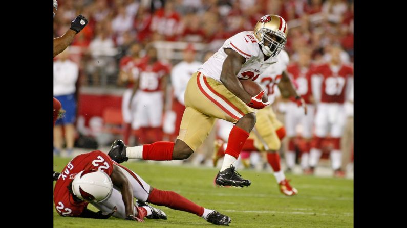 Frank Gore of the San Francisco 49ers leaps over William Gay of the Arizona Cardinals on a first-down run during the first quarter Monday.