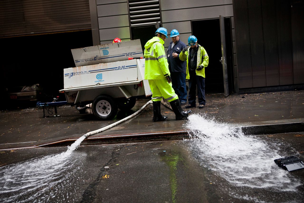 Con Edison employees monitor the drainage of water being pumped out of Seven World Trade Center in the Financial District of New York on Tuesday.