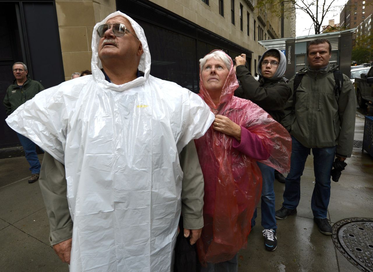 Onlookers watch a construction crane dangling from a $1.5 billion luxury high-rise after collapsing in high winds.