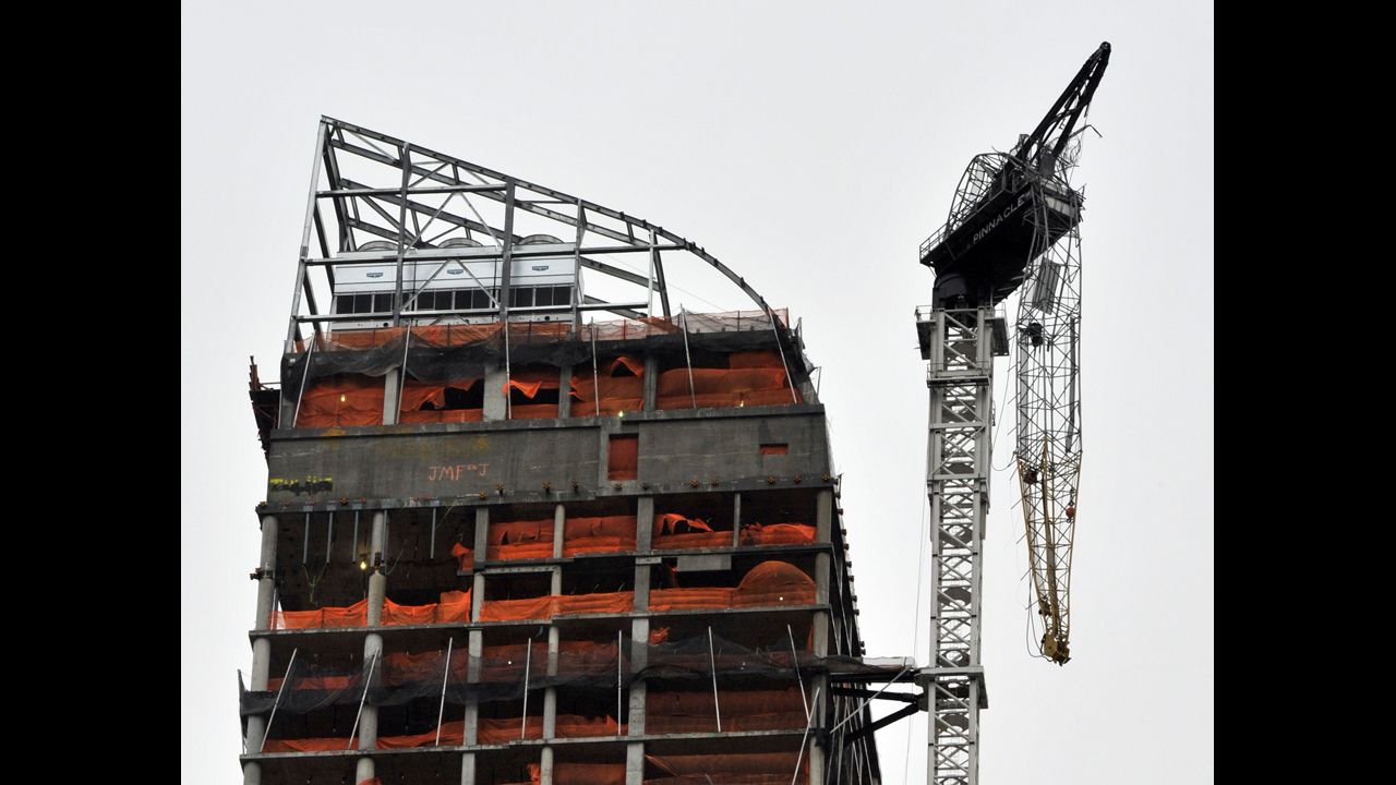 The construction crane dangles from a high-rise in midtown Manhattan.