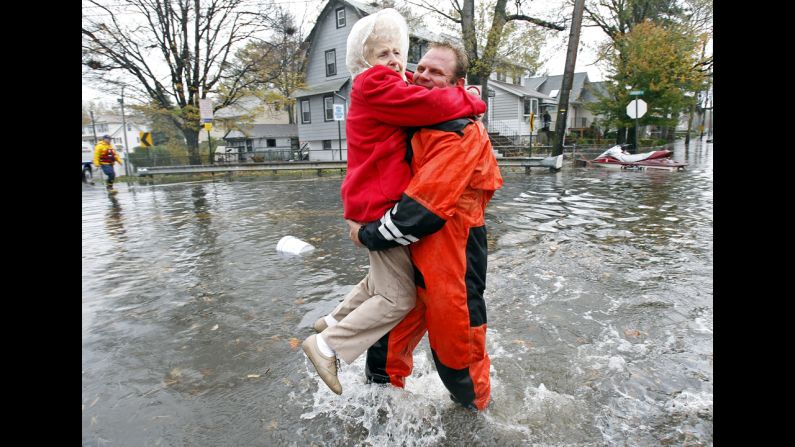 An emergency worker carries a resident through floodwaters in Little Ferry, New Jersey, on Tuesday.