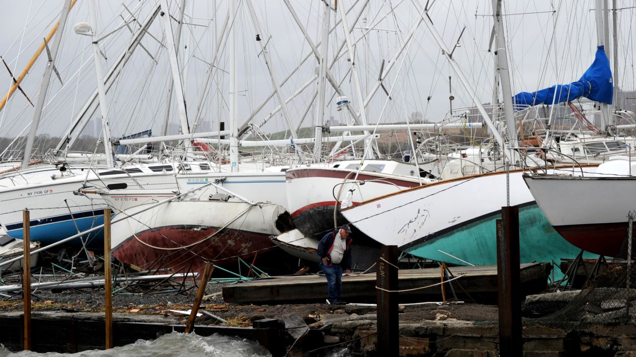 A man surveys damage to sailboats Tuesday at a marina on City Island in New York.