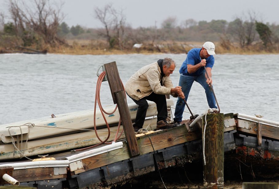 Ted Wondsel, left, of Point Lookout works on part of a dock destroyed in the storm in Long Beach on Tuesday.