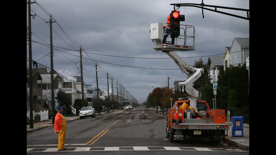 Utility workers repair a traffic signal damaged by the storm in Ocean City, New Jersey, on Tuesday.