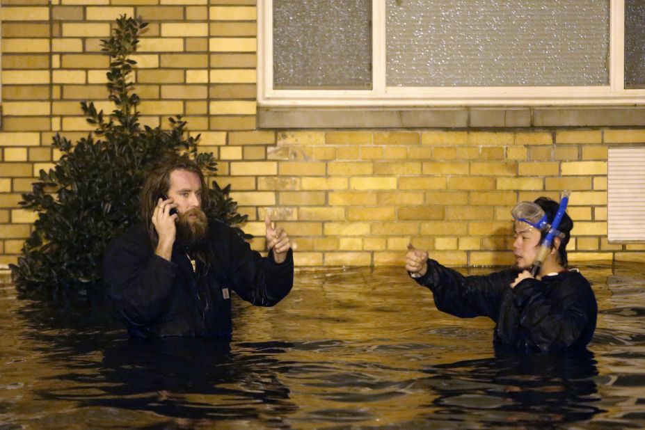 Two men wade through the flooded streets of Brooklyn on Monday as Sandy made landfall.