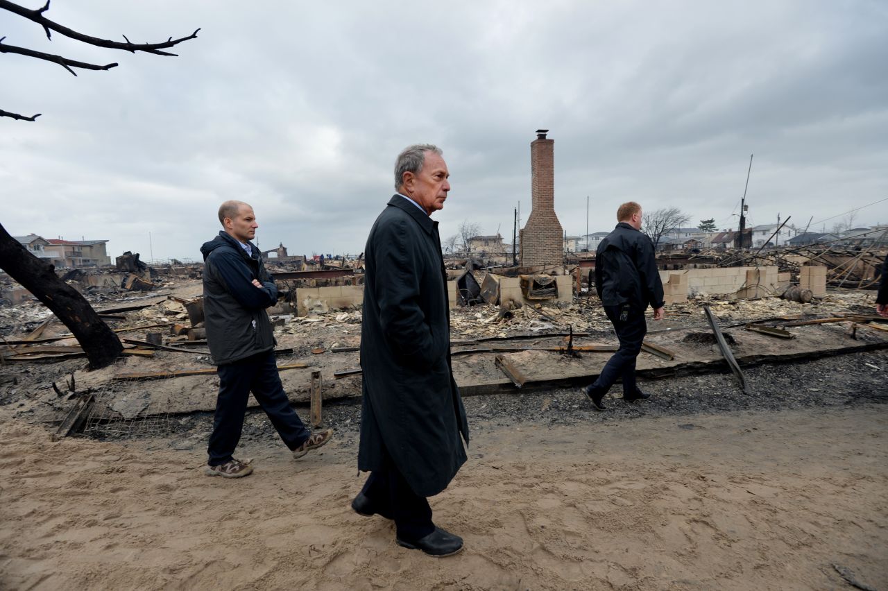 New York City Mayor Michael Bloomberg, center, views the damage Tuesday in the Breezy Point neighborhood of Queens, where a fire broke out during Superstorm Sandy and destroyed at least 80 homes.