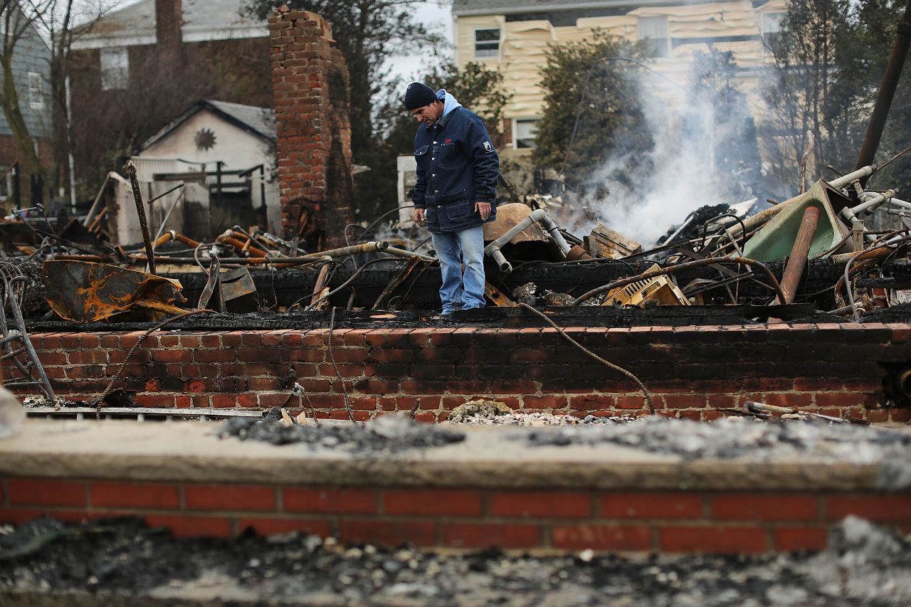 A  resident looks through the debris of his destroyed home in Breezy Point, Queens, on Tuesday.