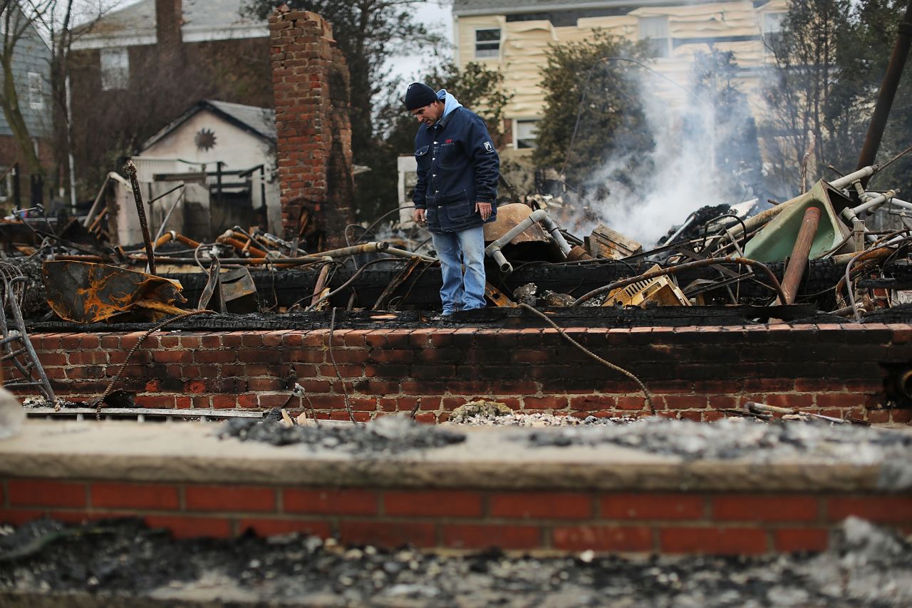 A resident looks through the debris of his destroyed home in Breezy Point, Queens, on Tuesday.