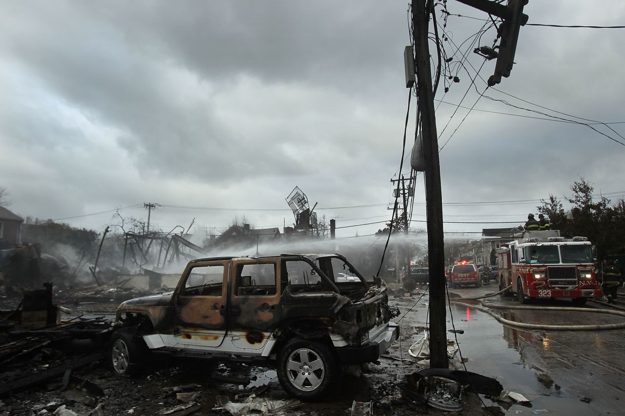 Burned-out vehicles and destroyed homes line a street in Breezy Point, located on the western end of the Rockaway peninsula in New York.