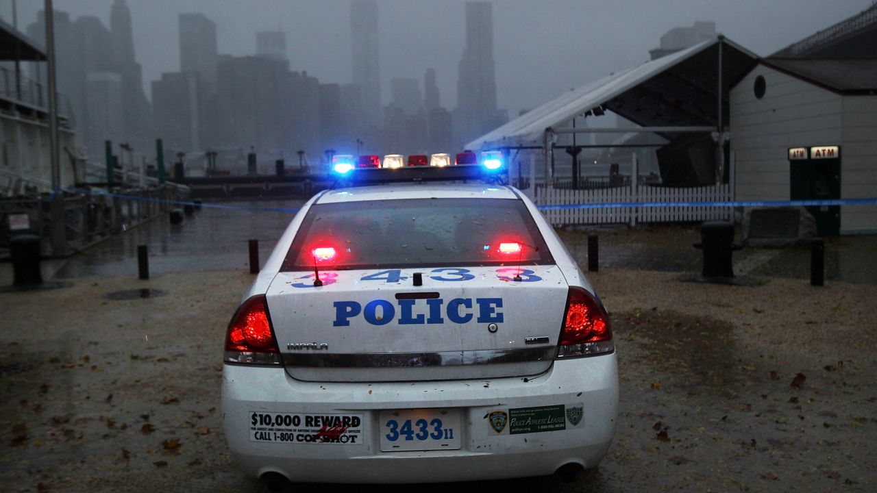 A police car looks out over Manhattan from near the Brooklyn Bridge as Sandy begins to affect the area on Monday.