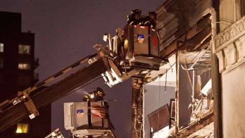Firefighters evaluate an apartment building in New York City where the front wall collapsed due to Hurricane Sandy on Monday.