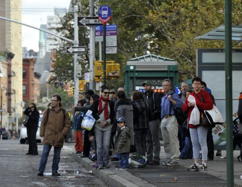 People wait for buses on Sixth Avenue in New York on Wednesday as New Yorkers cope with the aftermath of Hurricane Sandy.