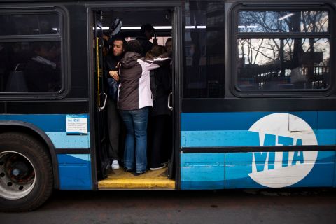 People attempt to squish into a crowded bus on First Avenue in New York on Wednesday.