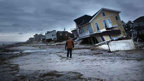 A man surveys damage on Wednesday, October 31, in the Rockaway neighborhood of Queens, New York, where the historic boardwalk was washed away during Superstorm Sandy. 