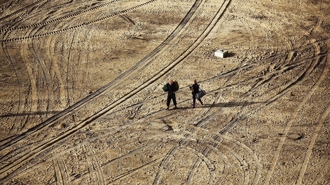 Residents walk with their belongings through the Rockaway section of Queens on Wednesday.
