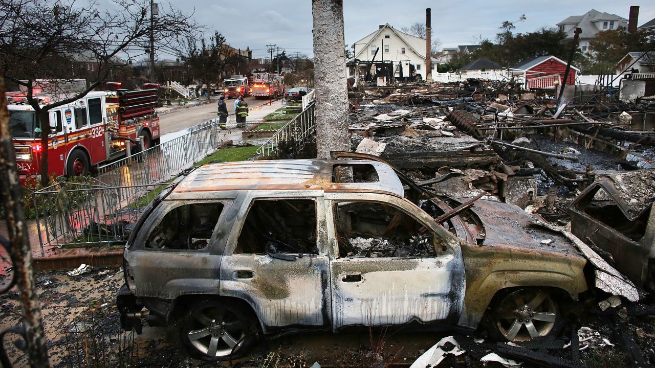 The remains of homes burned down in Rockaway are seen Wednesday, a day after an inferno spread across the flooded neighborhood.