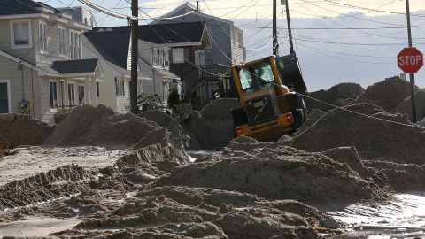 Earth movers push sand off the road that was washed in from Hurricane Sandy on October 31, 2012 in Long Beach Island, New Jersey. 
