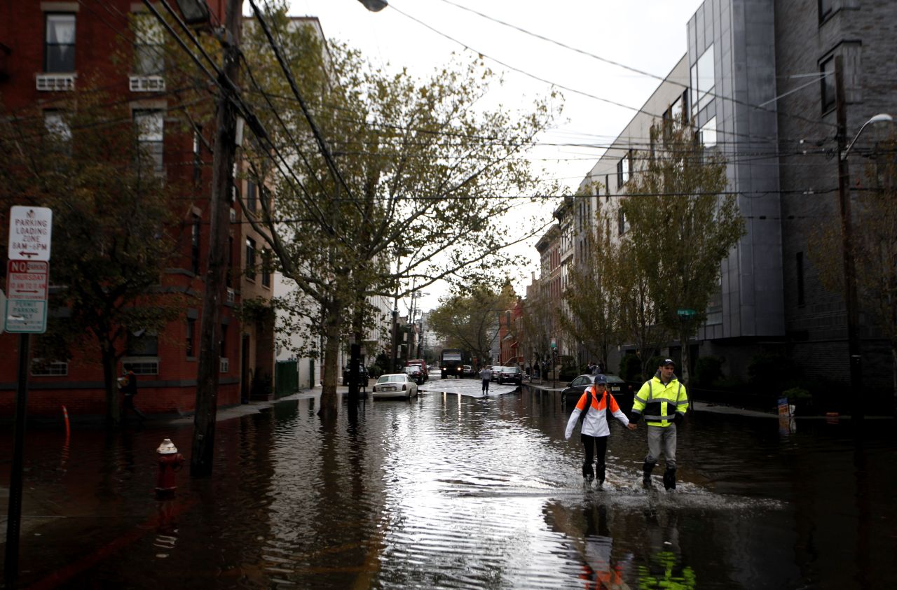 Residents traverse flooded streets as clean up operations begin in Hoboken, New Jersey.