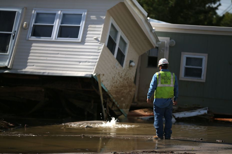 New Jersey Natural Gas technician Carlos Rojas inspects a leaking gas main that is under water at a home damaged by Hurricane Sandy in Long Beach Island, New Jersey.