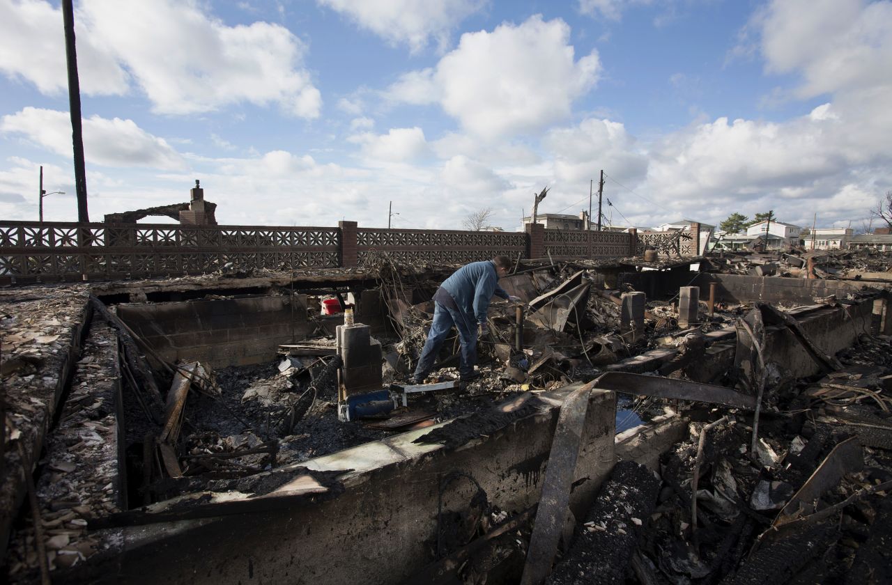 A resident looks through the remnants of his home in the Breezy Point neighborhood of Queens, New York.