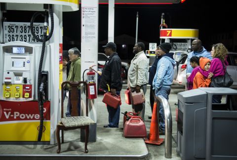 People wait in line to fill containers with gas at a Shell station in Edison, New Jersey, on Tuesday. Superstorm Sandy left much of Bergen County flooded and without power.