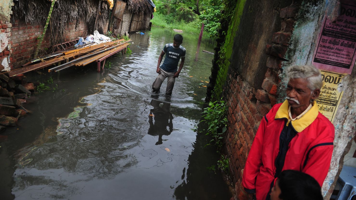 An Indian man wades through a flooded street in Chennai on October 31, 2012. 