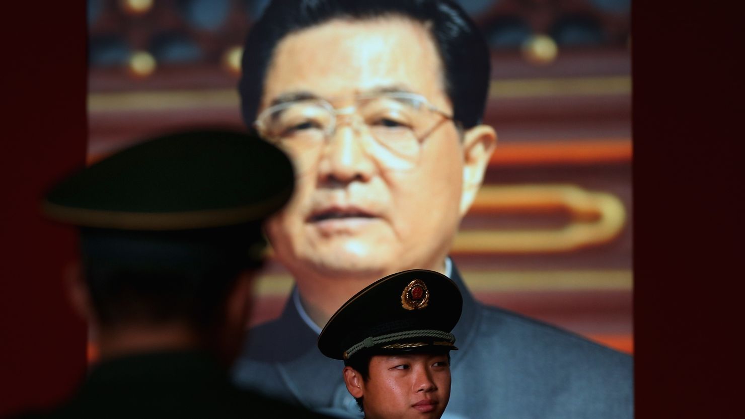  A paramilitary policeman passes by the portrait of China's President Hu Jintao at a state-sponsored exhibition in Beijing Tuesday.