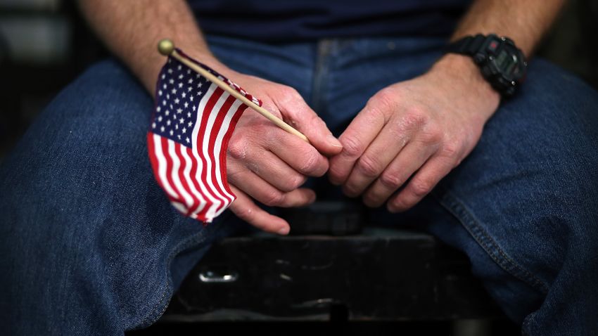 A Mitt Romney supporter holds an American flag during a campaign event at Meadow Event Park.