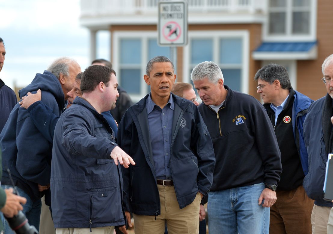 President Obama listens to local officials as they tour damaged areas.