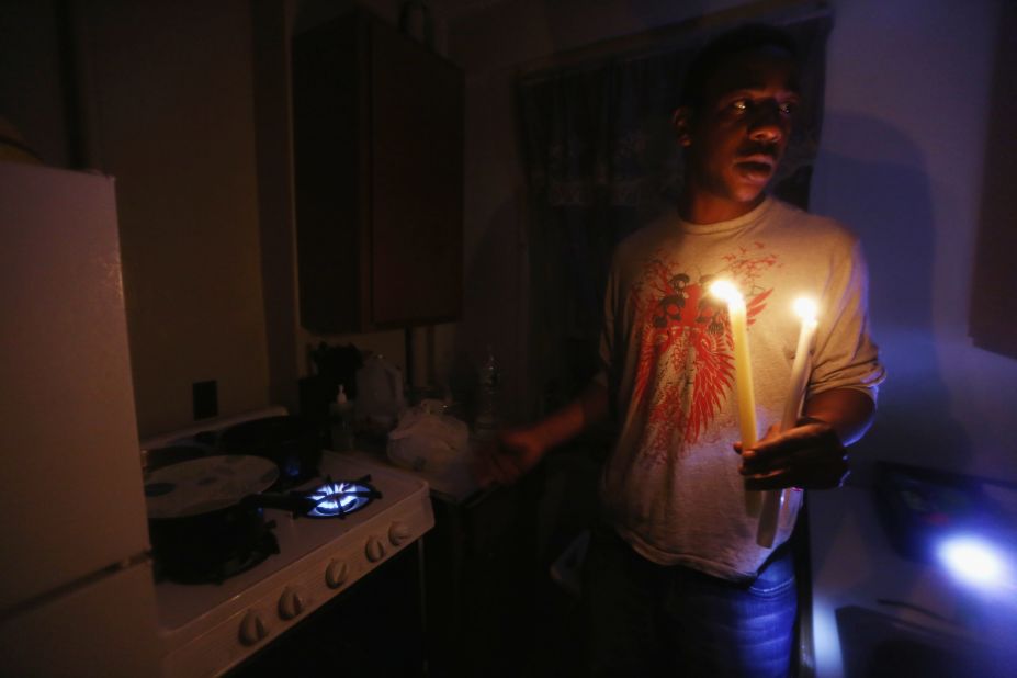 Geronimo Harrison's apartment in the East Village remains without power or water Thursday. He's using candles for light and a gas stove for heat.