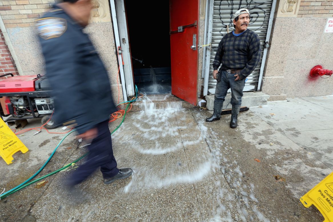 Water gets pumped out of a business in the East Village on Thursday.