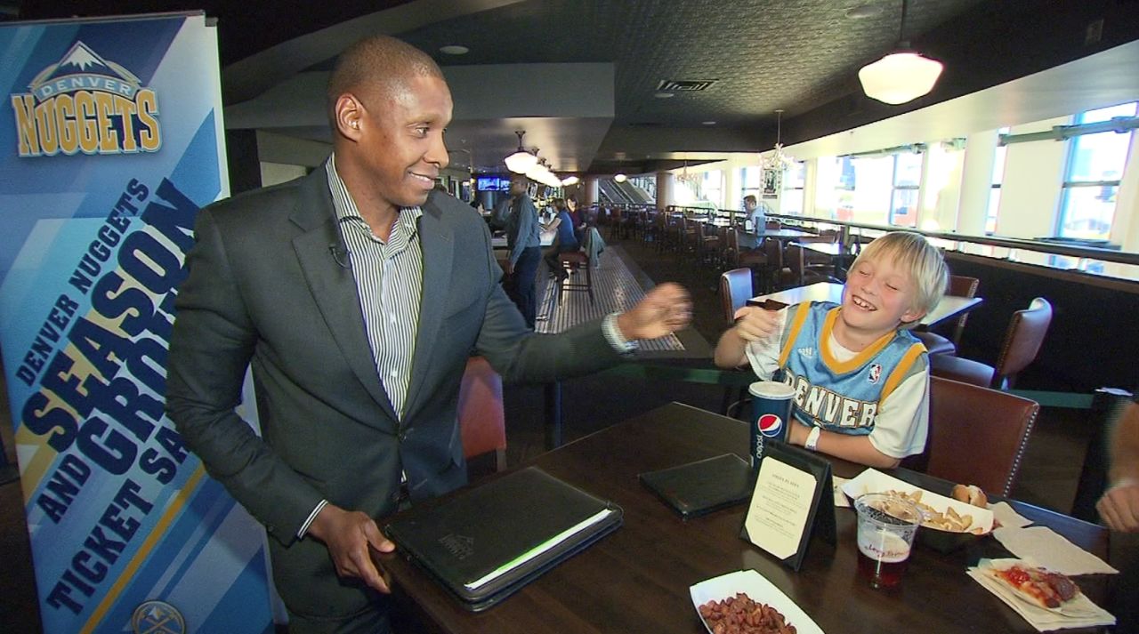 Ujiri bumps fists with a young Nuggets fan in Denver.