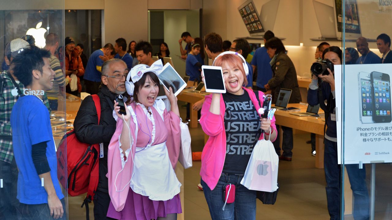 Customers show their newly purchased iPad Mini tablets at an Apple store in Tokyo on Friday.
