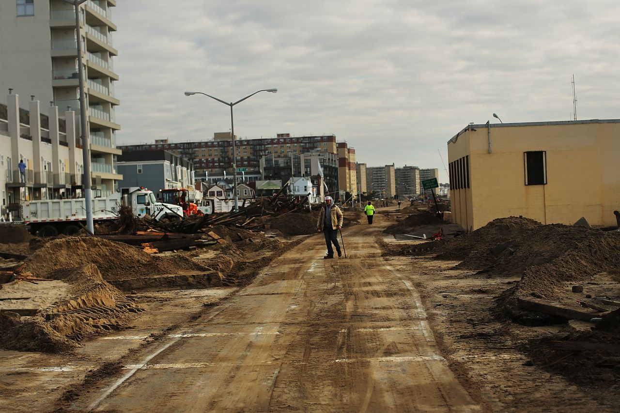 People walk through the heavily damaged Rockaway neighborhood.