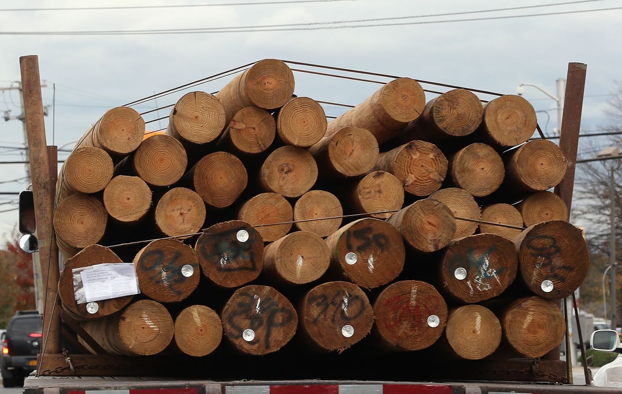 In the aftermath of Superstorm Sandy, replacement power utility poles are transported along Old Country Road on Friday in Plainview, New York.