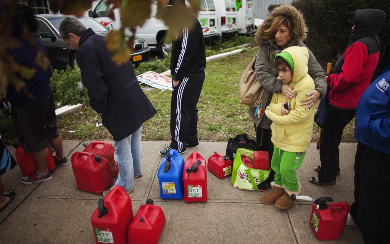 Michelle Dumas hugs her daughter Olivia to warm her up as they wait in an hours-long line for gas at a station Friday on Staten Island.