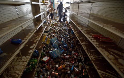 Men try to clean up the destruction in a flooded deli in Brooklyn, New York, on Friday.