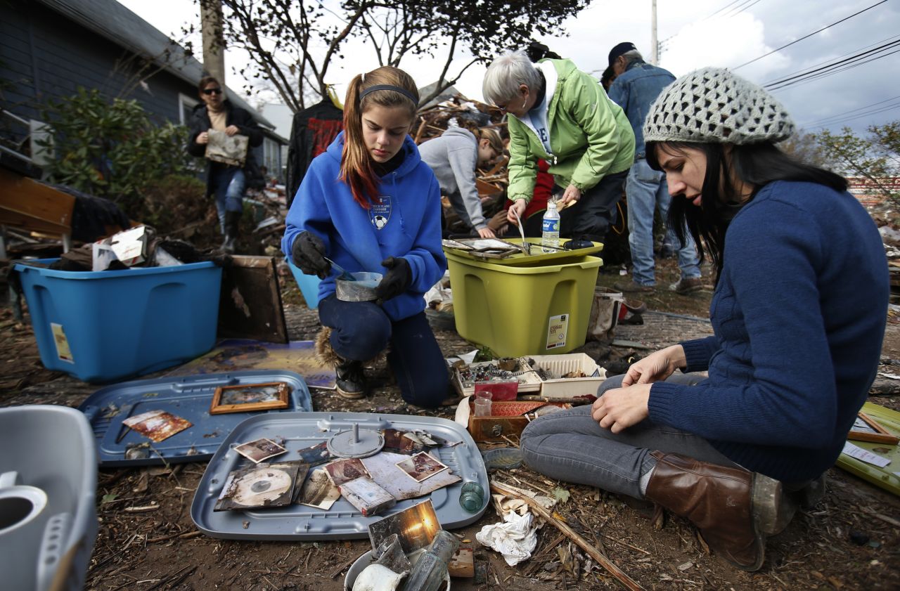 Members of the Traina family on Friday sort through photographs and other personal items from their Staten Island home that was destroyed by Superstorm Sandy.