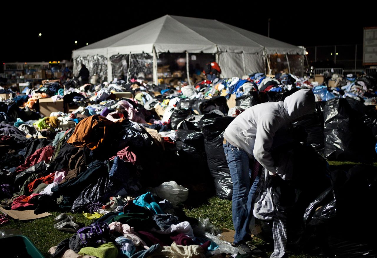 A volunteer places donated clothing in plastic bags to protect it from potential rain at a relief center on Saturday in Midland Beach.