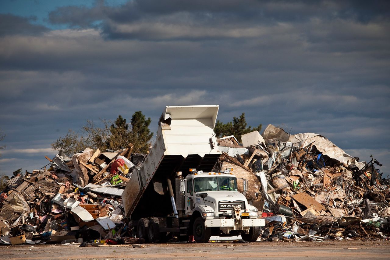 A dump truck empties trash collected from homes damaged by Superstorm Sandy on Saturday, November 3, in the Midland Beach neighborhood of Staten Island, New York. New York is trying to clean up and resume normal activities days after the storm hit.
